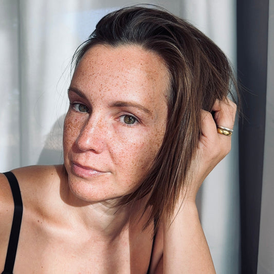 woman in forty's with hand on her head after arena self care routine
