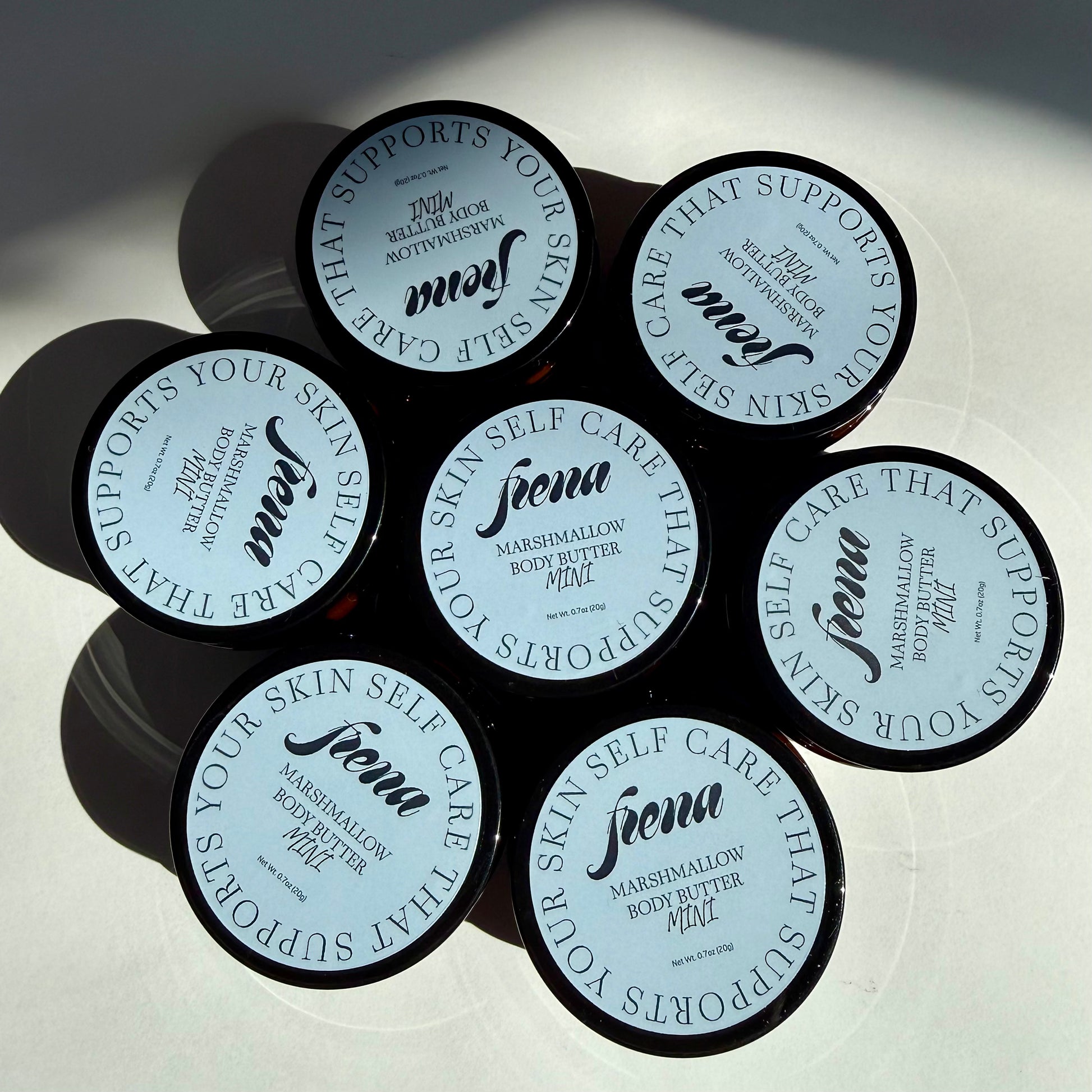 Marshmallow body butter in mini size. Several in a flower pattern. 